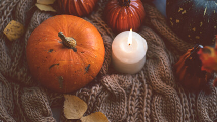 Autumn background with dry leaves, blue cup of coffee. Knitted background, pumpkins, October, November. Autumnal atmosphere. Autumn season.