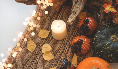 Autumn background with dry leaves, blue cup of coffee. Knitted background, pumpkins, October, November. Autumnal atmosphere. Autumn season.