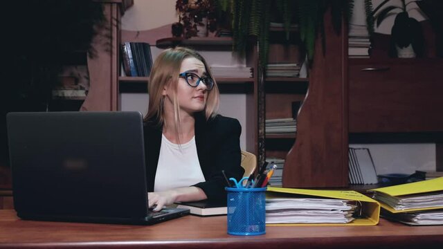A lot of Paperwork and sad woman. Bored sad worker tired unmotivated and disinterested in dull work with laptop paperwork. Office clerk working, adding folders more work.
