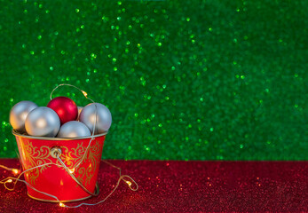 Christmas composition. Silver balls in a red bucket on a green and red background. Copy space. New Year.