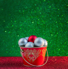 Christmas composition. Silver balls in a red bucket on a green and red background. Copy space. New Year.