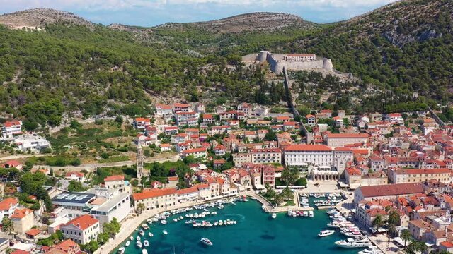 Aerial footage with backward motion of the Hvar old town with its famous luxury marina by the Adriatic sea in Croatia