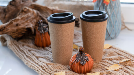 Autumn background with dry leaves, blue cup of coffee. Knitted background, pumpkins, October, November. Autumnal atmosphere. Autumn season.