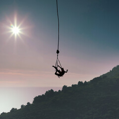 Silhouette of a young woman bungee jumping