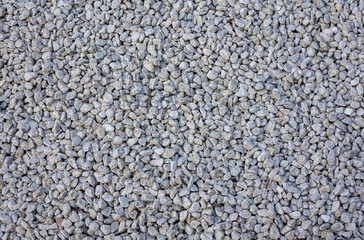 Crushed gravel texture background in daylight, background made of a closeup of a pile of crushed stone, pile of pebbles. Gravel stone background or texture and free space for text.
