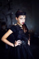
Halloween style girl in long black dress and crown