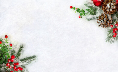 Christmas decoration. Frame of twigs christmas tree, brown natural pine cones, ball, red apple and red berries on snow with space for text. Top view, flat lay