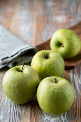 Granny smith organic apples close up on wooden rustic table for a grocery store catalogue