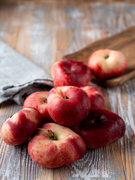 Pile of flat fuzzy peaches close up on wooden rustic table for a grocery store catalogue