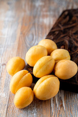 Pile of light orange apricots on wooden table close up