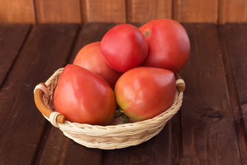 Freshly picked tomatoes on a dark wooden background.