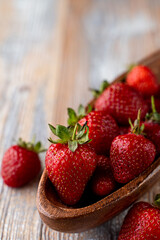 A whole wooden bowl of ripe seasonal strawberries, close up, side view, advertisement appetizing photo