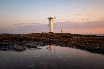 Lighthouse in the morning on the Baltic Sea with windmill wings in Swinoujscie, Poland © Lukas Uher