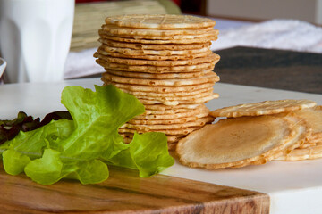 Stack of dry biscuits and lettuce.