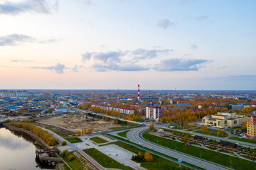 Fototapeta premium Industrial city on the river Bank. Shooting from a drone in the setting sun.