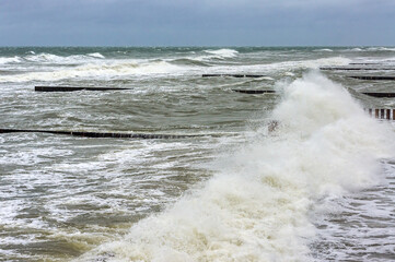 Breakwaters in the sea. Waves beat against breakwaters. Splashing sea waves.