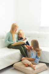 little child together reading a book on the sofa