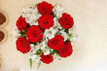 Bouquet with red roses and white flowers in round box. View from above.