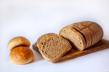 
Bread and buns on the kitchen board. Sliced ​​bread. Appetizing bread in the photo