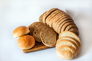 
Bread and buns on the kitchen board. Sliced ​​bread. Appetizing bread in the photo