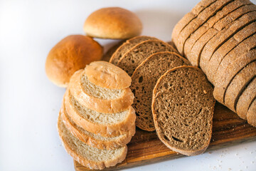 
Bread and buns on the kitchen board. Sliced ​​bread. Appetizing bread in the photo