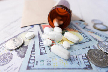 Healthcare cost concept with us dollar , container and pills on table 