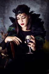 
Girl in Halloween style with a glass in hand