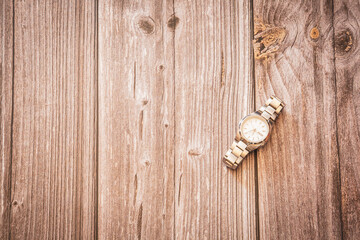 A mens silver wrist watch on a rustic wooden background with copy space