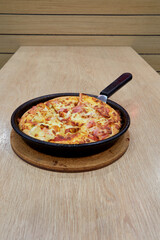 Italian Pizza in chopping board on a wooden table
