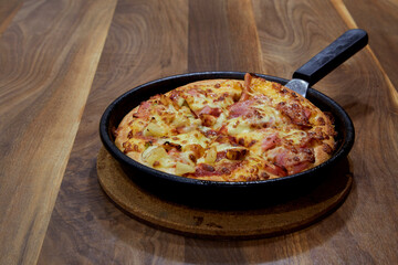 Italian Pizza in chopping board on a wooden table