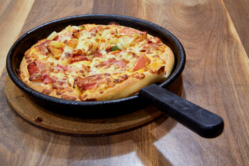 Italian Pizza in chopping board on a wooden table