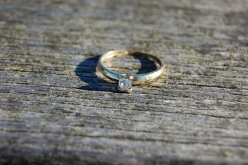 A beautiful engagement ring placed on a wooden board