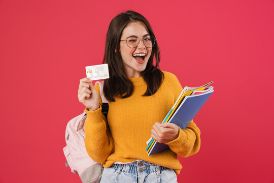 Image of excited student girl posing with credit card and exercise books