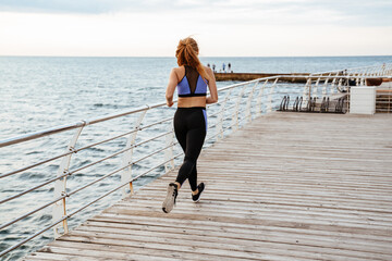 Image from back of athletic sportswoman running while working out