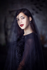 Fototapeta na wymiar Girl in Halloween style with a veil on her head in the studio