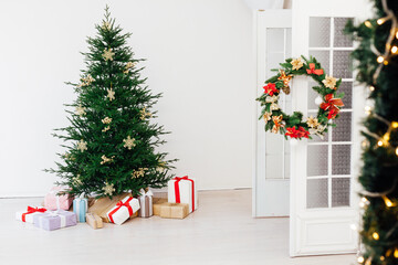 Stylish Christmas scandinavian minimalistic interior Christmas tree with light and bauble in sunny living room