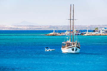 Fototapeta na wymiar White yacht in the sea next to the coastline with mountains in the background