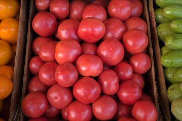 Background of red tomatoes that are sold in the open-air vegetable market.