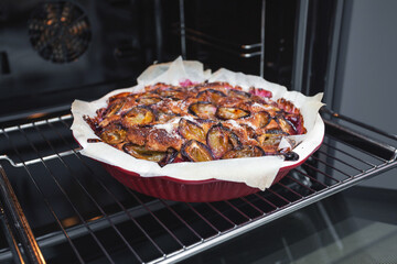 Freshly baked rustic plum cake at home in the oven in the kitchen. Homemade baking.