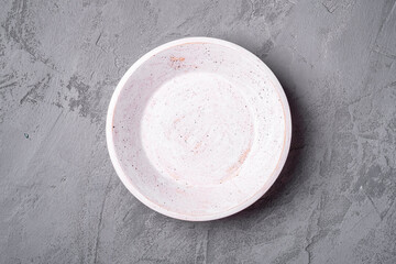 Empty round handcrafted white wooden plate on stone concrete background, top view