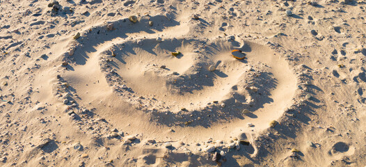 Swirling spiral pattern on the sand with footprints on Cape Cod beach. Panoramic grunge image for...