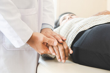 Doctor encouraging patient during treatment therapy and holding hands to support.