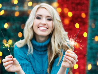 Beautiful smiling woman with sparkles has fun outdoors