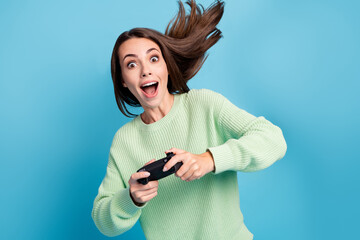 Photo portrait of pretty funny girl playing video game keeping console shouting loudly isolated on vibrant blue color background © deagreez