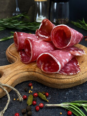 Delicious juicy salchichon sausage sliced on a wooden board.