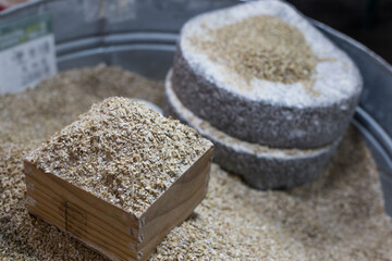 Barley beans with millstone. Grains of malt close up.