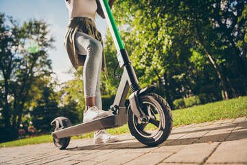 Cropped view of her she teenage teen trendy skinny slim fit hipster girl's legs riding kick scooter spending free time sunny day having fun activity sport in forest wood outdoor youth hobby - obrazy, fototapety, plakaty