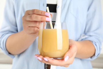 Woman holding tasty pear juice in glass, closeup