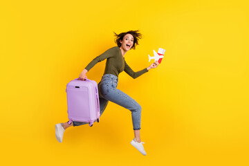 Full size profile side photo of crazy girl jump run fast with luggage plane visa isolated on shine yellow color background