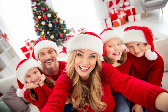 Full family x-mas eve tradition event. People mom dad three preteen little kids make selfie chatting relatives wear santa claus hats in house with christmas noel decoration